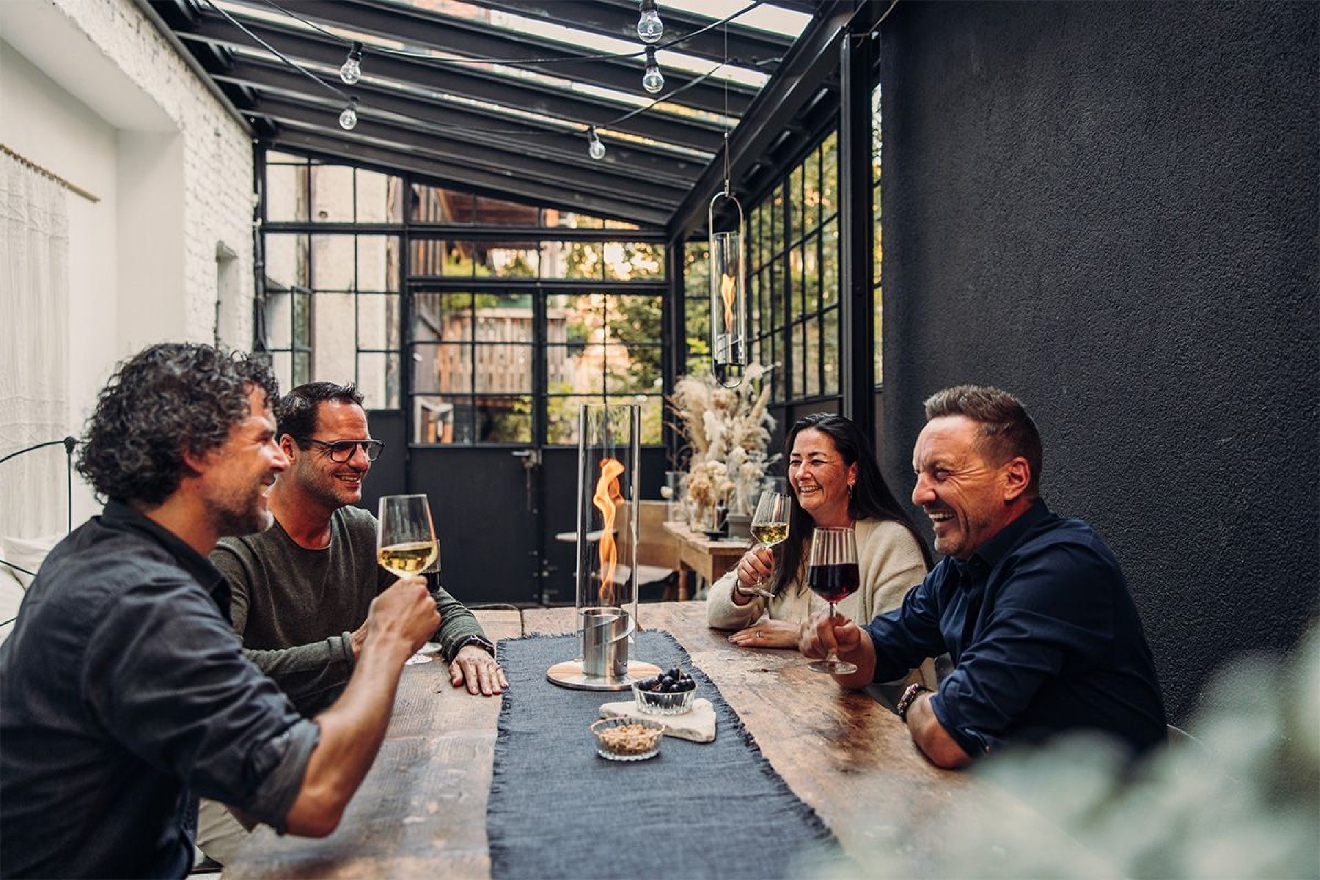 höfats SPIN 90 Tischfeuer bei einem Glas Wein